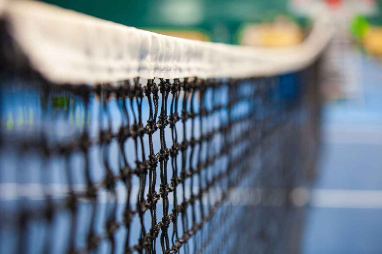 Close up of tennis court through the net