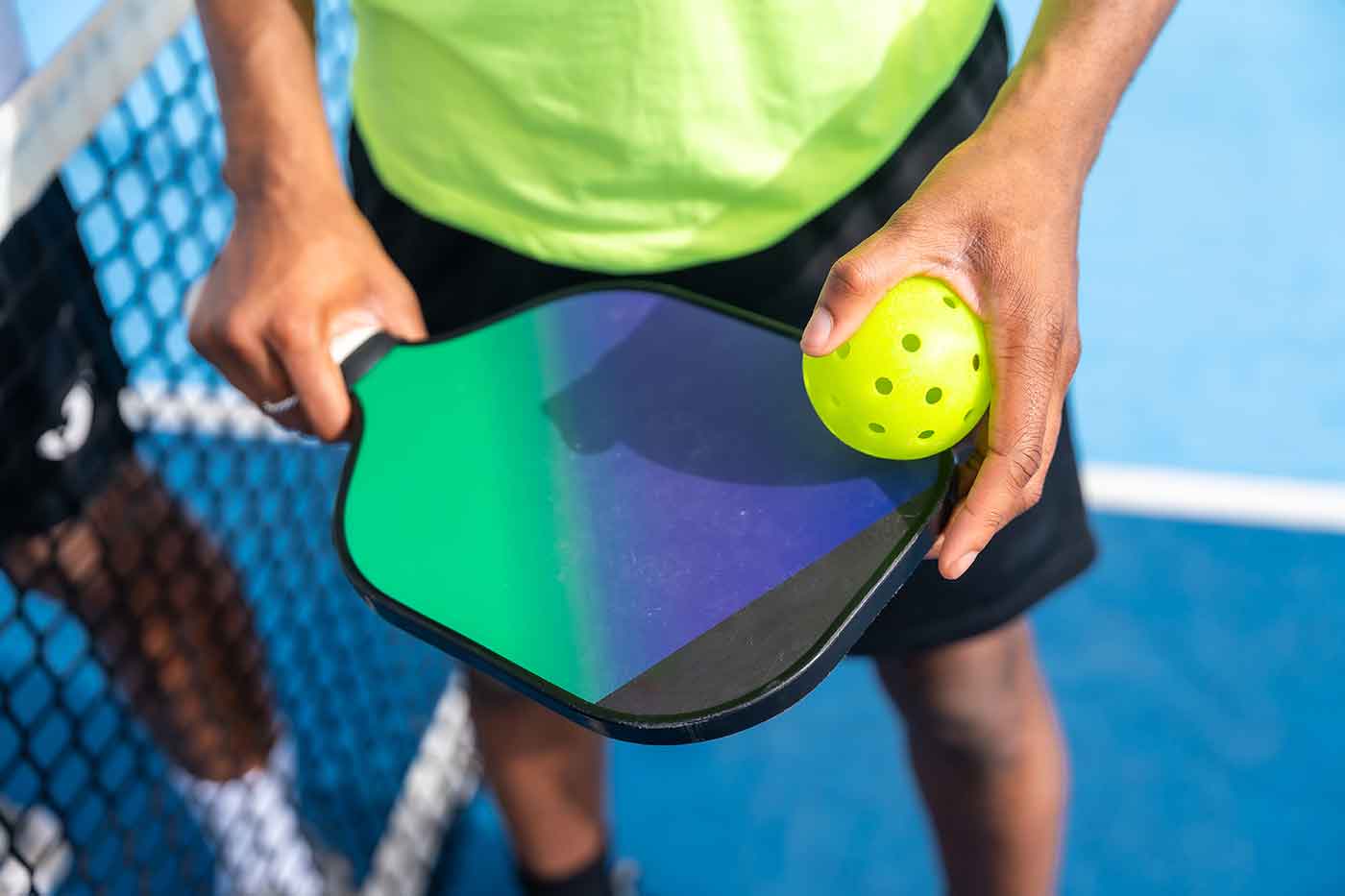 top-view-closeup-man-holding-racket-pickleball-ball-1400